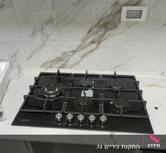 כיריים גז שחורות עם חמישה מבערים וכפתורים כסופים